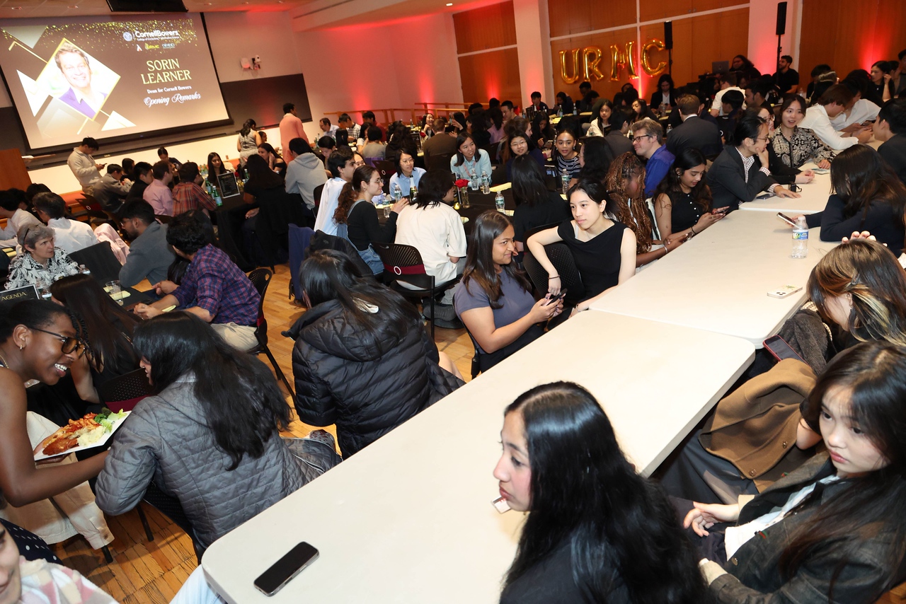 A color photo showing an awards ceremony with people seated.