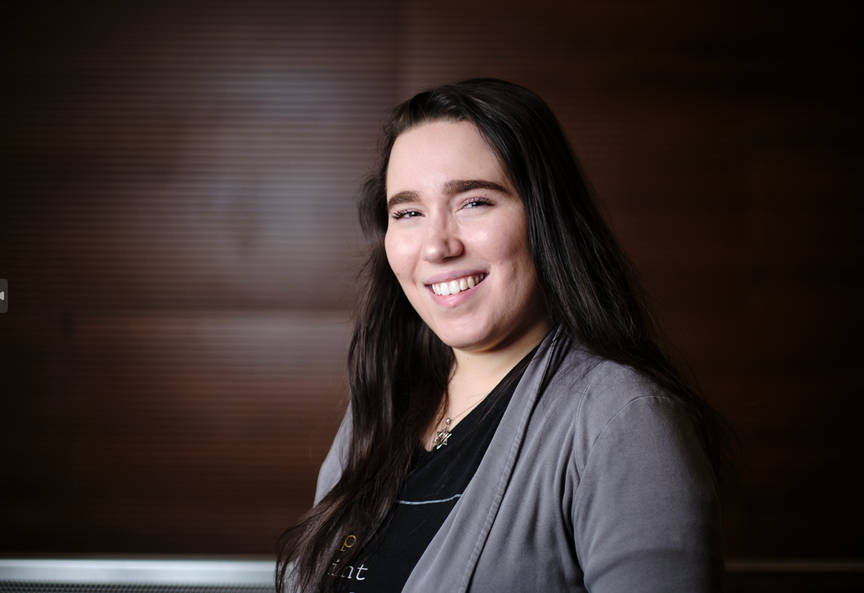 A color photo of a woman smiling for a photo