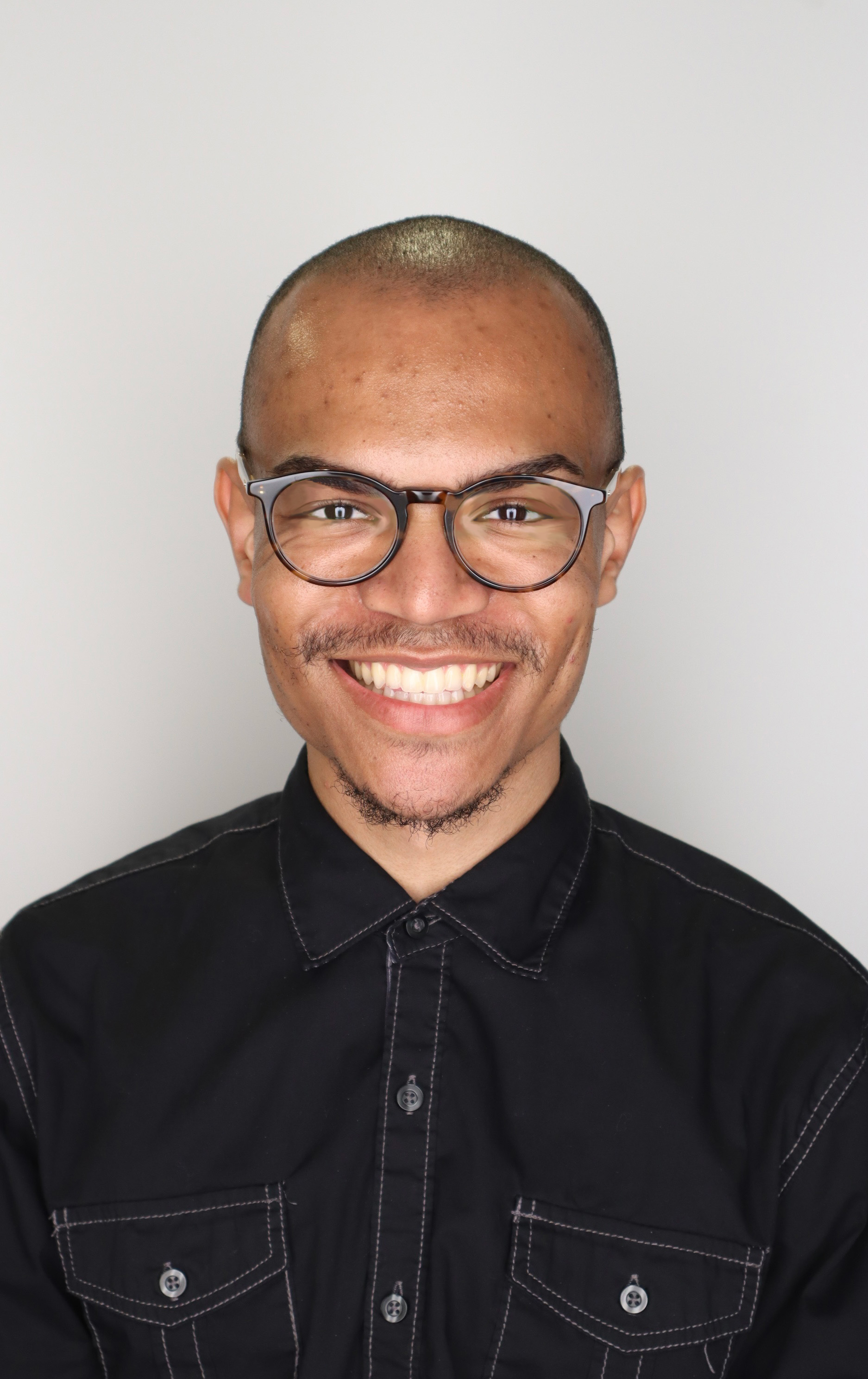 A color photo of a man smiling for a photo