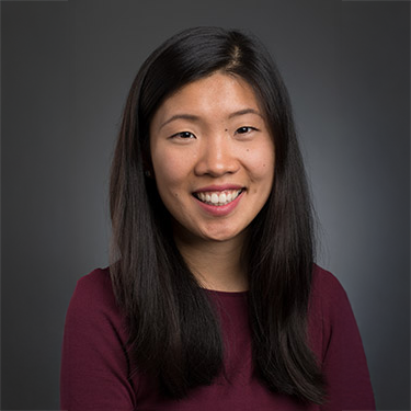A color photo of a woman smiling for a photo