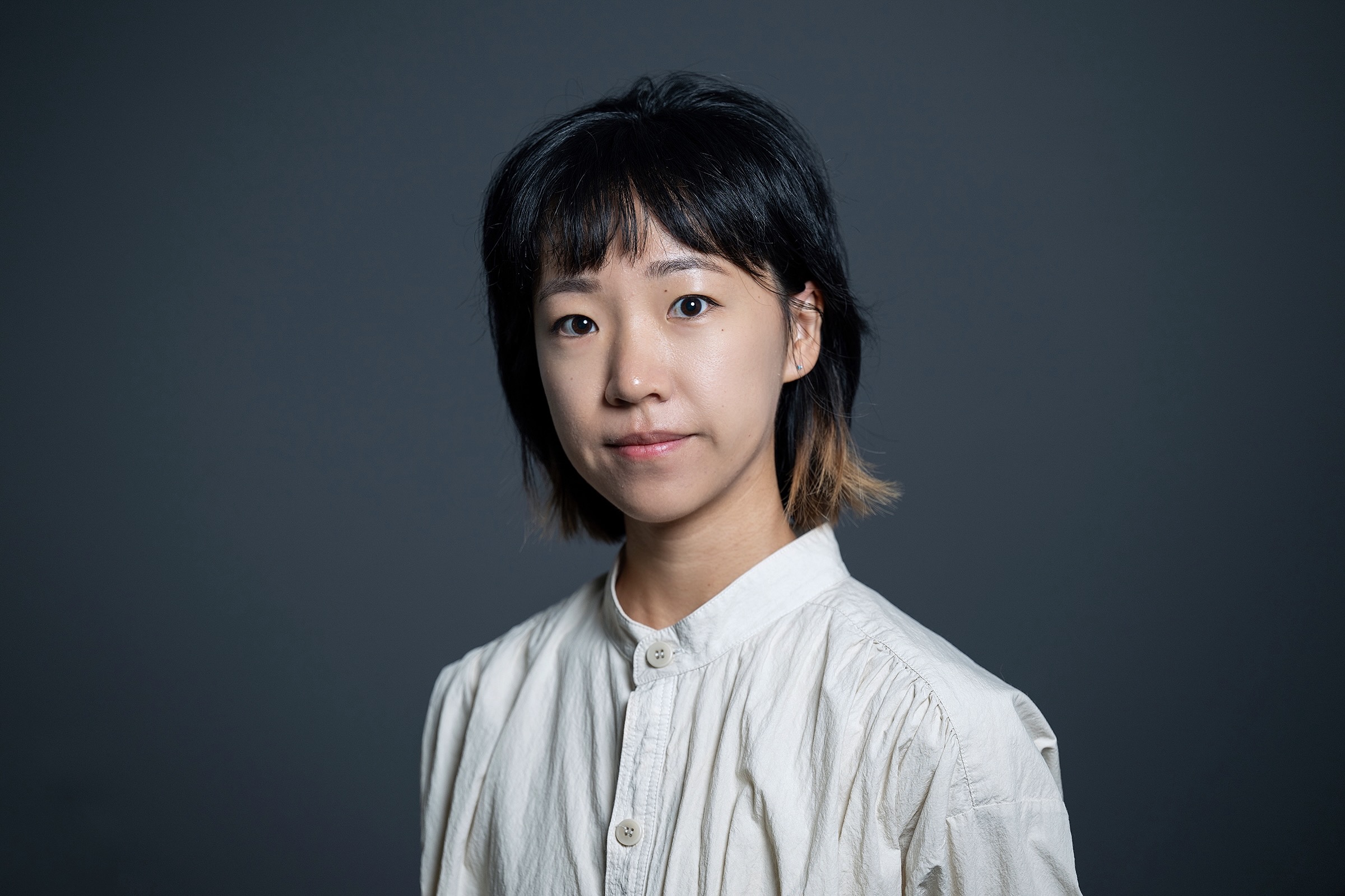 A color photo of a woman smiling for a photo