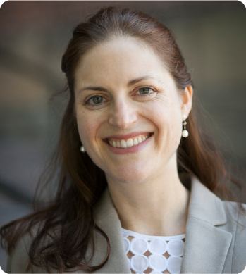A color photo of a woman smiling for a photo.