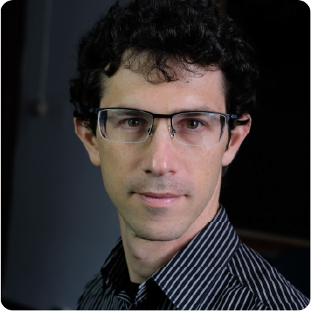A color photo of a man with glasses.