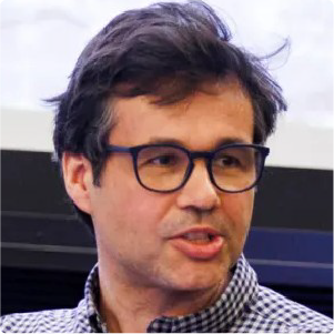 A color photo of a man with glasses.