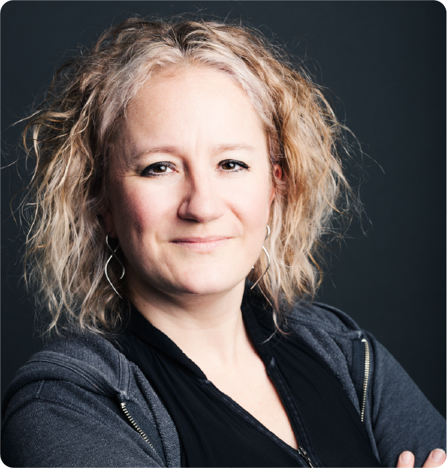 A color photo of a woman smiling for a photo.