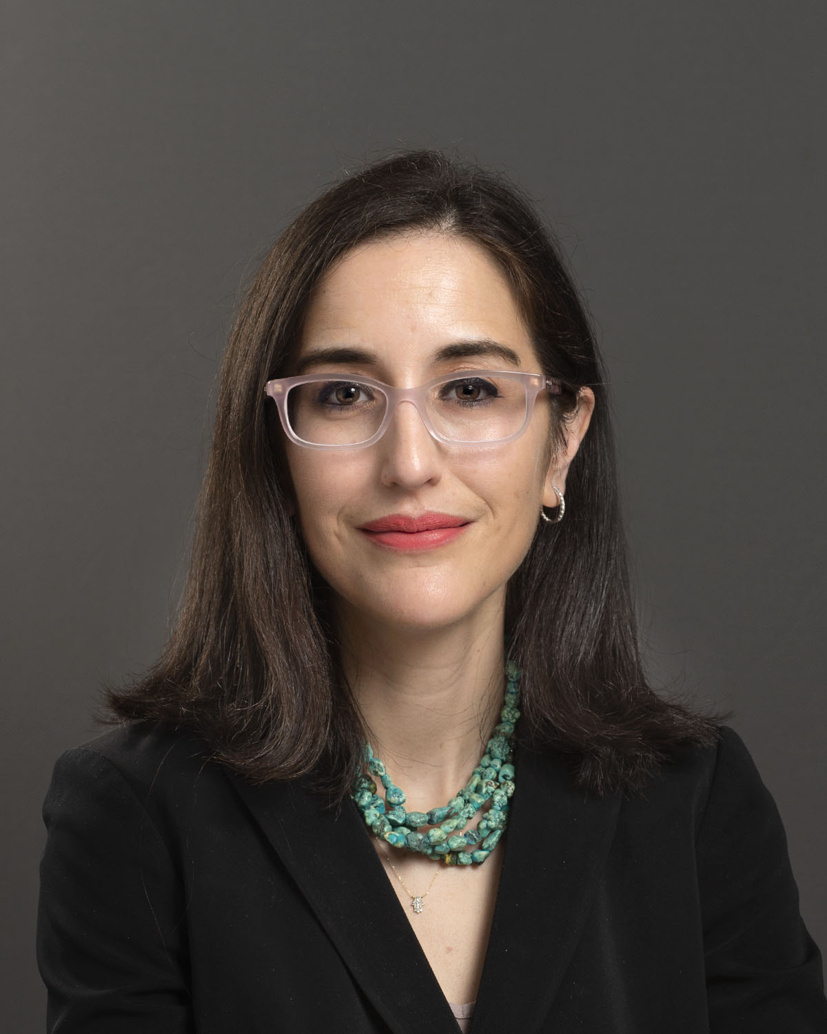 A color photo of a woman smiling for a photo