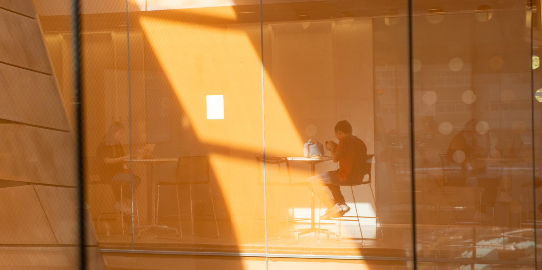 orange colored walls and glass panes reflect light in Gates Hall interior walls