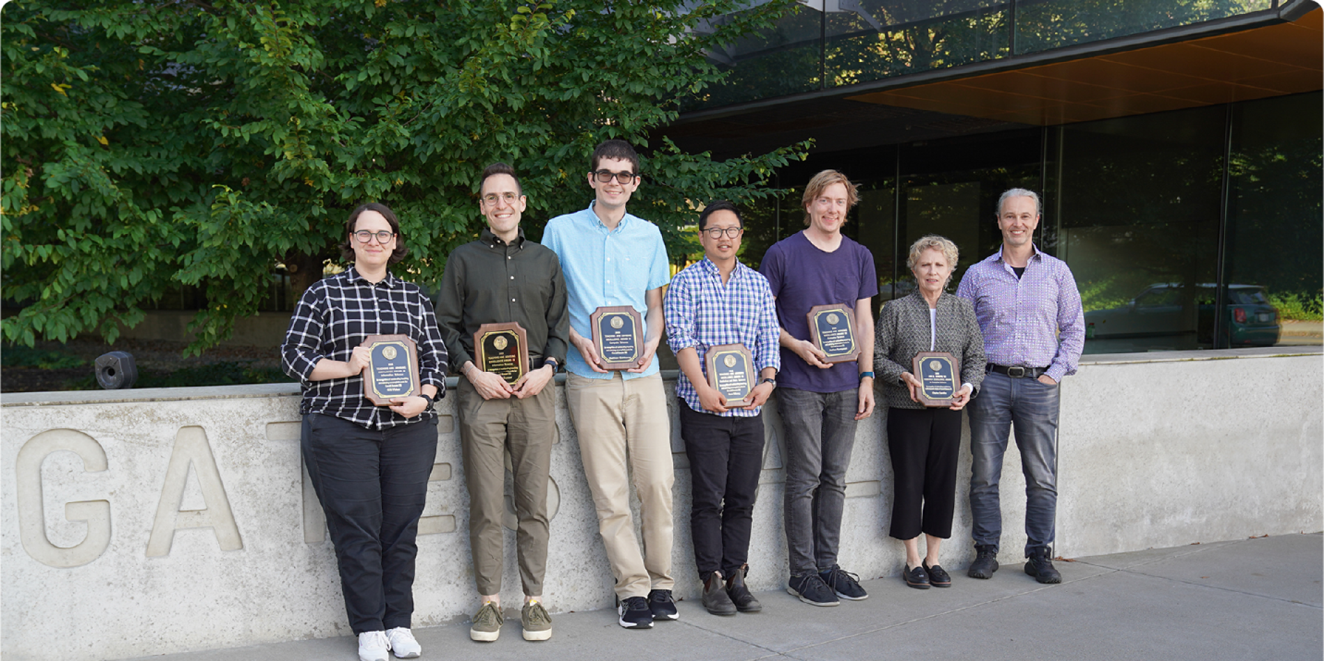 A color photo showing the faculty award winners with their plaques.