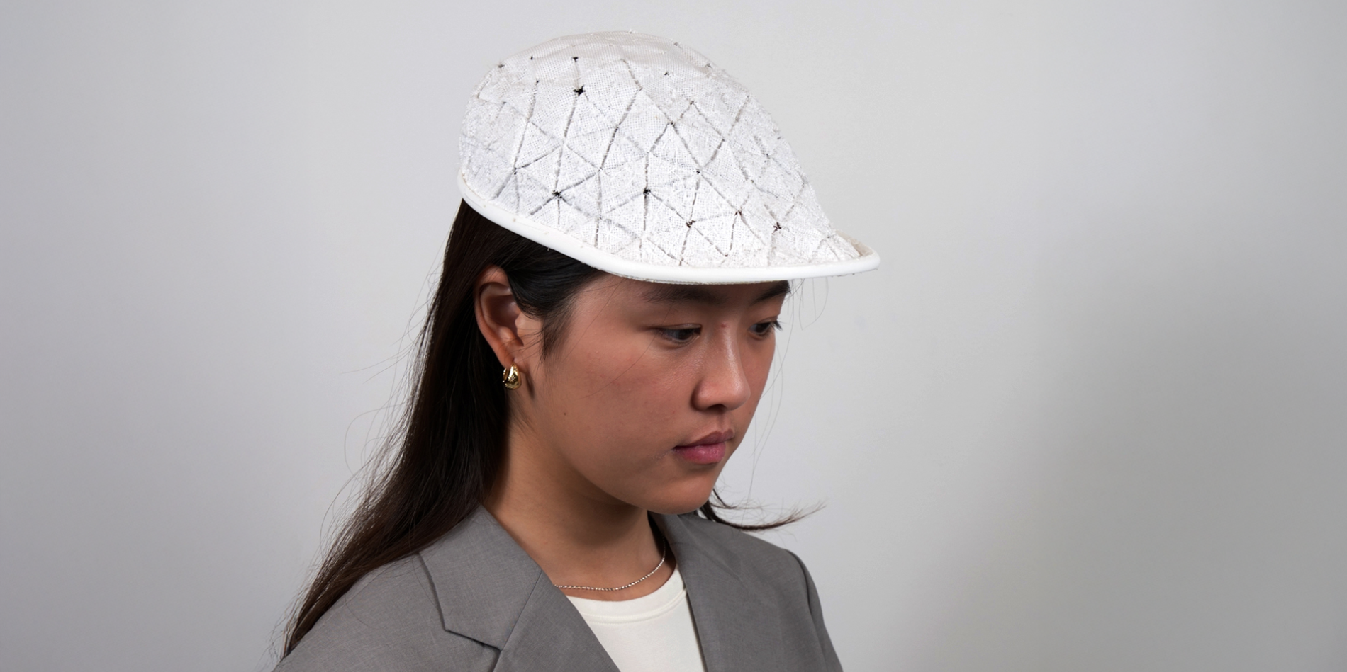 A color photo of a woman wearing a white cap.
