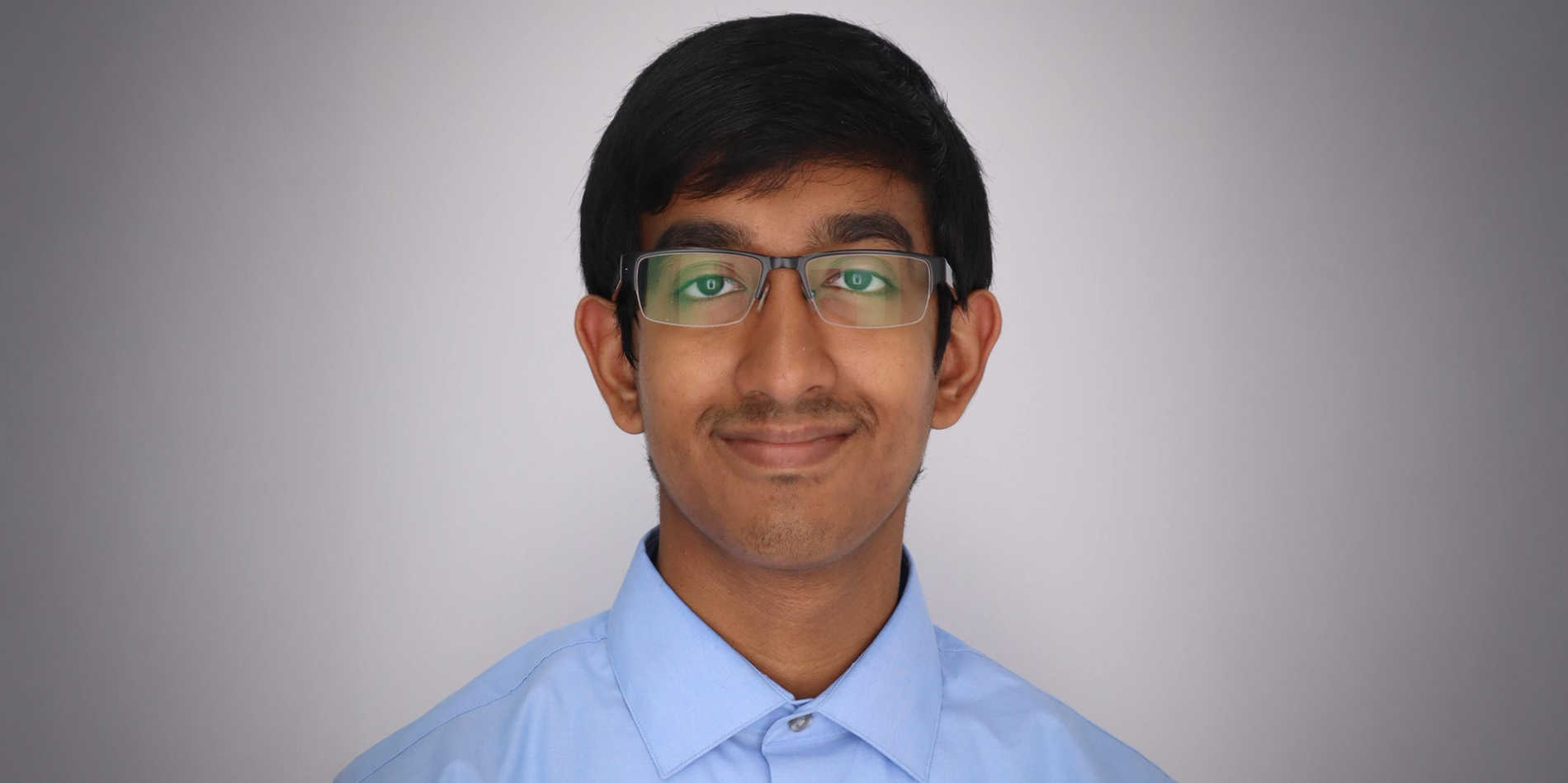 A color photo of a man smiling for a photo.