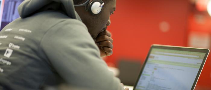 a black male student works on a laptop