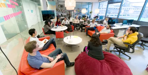 Group of students and faculty having a discussion in a collaborative workspace.