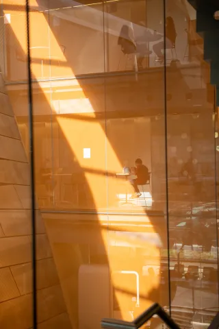 orange colored walls and glass panes reflect light in Gates Hall interior walls