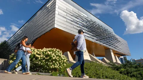 three students walk past Gates Gall