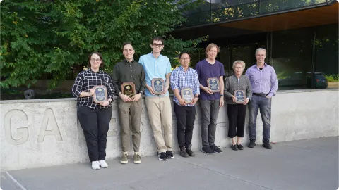 A color photo showing the faculty award winners with their plaques.