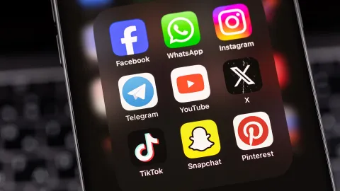 A color photo of a smart phone with social media icons.
