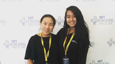A color photo of 2 women smiling for a photo.