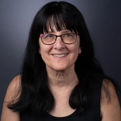 color portrait of woman with long dark hair and glasses