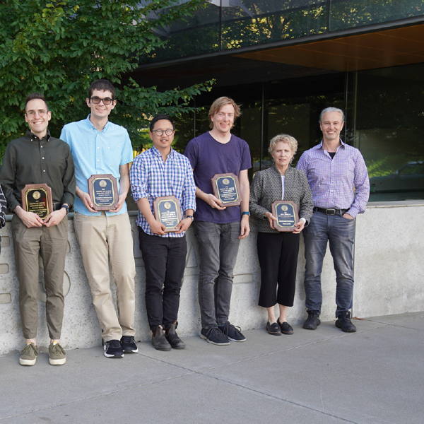A color photo showing the faculty award winners with their plaques.