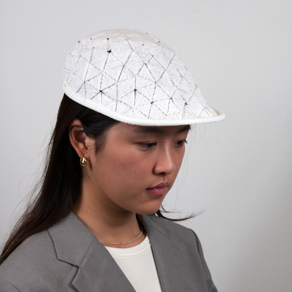 A color photo of a woman wearing a white cap.