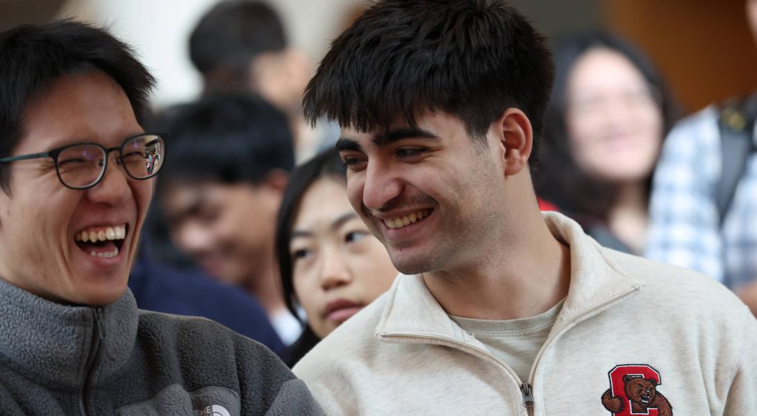 A color photo showing 2 men laughing.