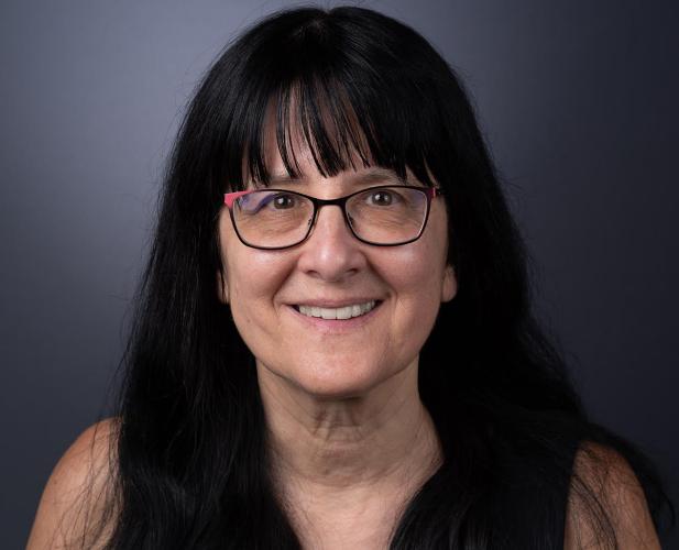 color portrait of woman with long dark hair and glasses