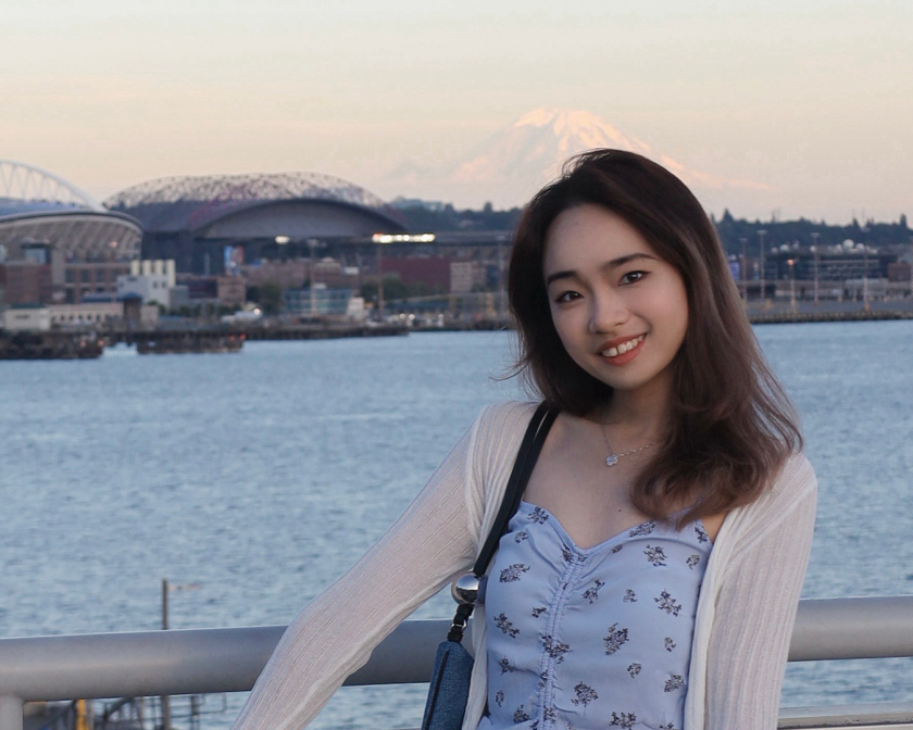 A color photo of a woman in front of a waterfront area in Japan.
