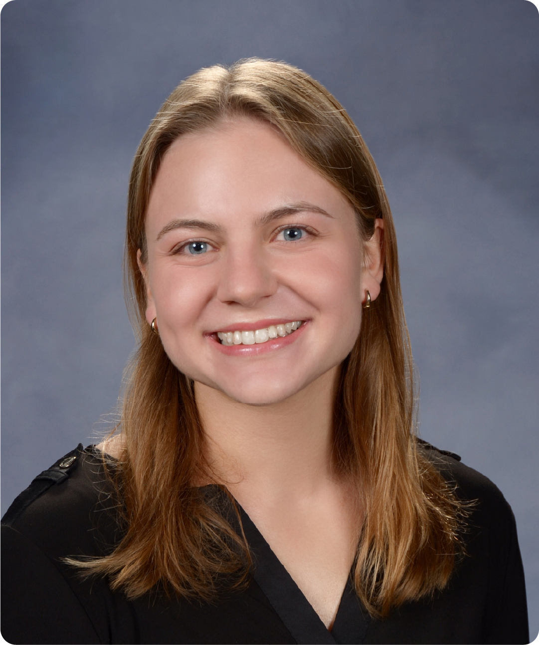 A color photo of a woman smiling for a photo.